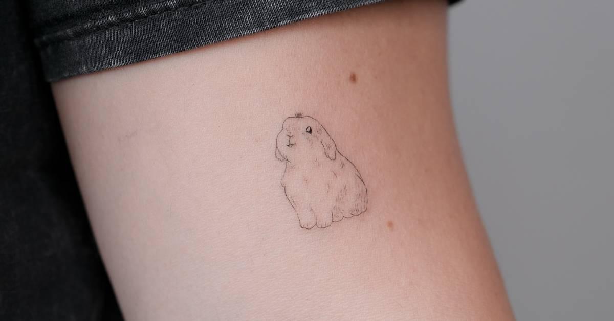 Little rabbit tattoo in fine line style located on the