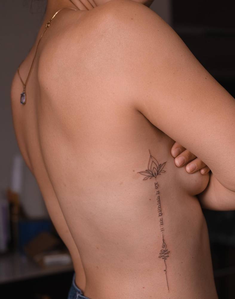 Hand poked lotus unalome and hindi lettering tattoo located on the rib.