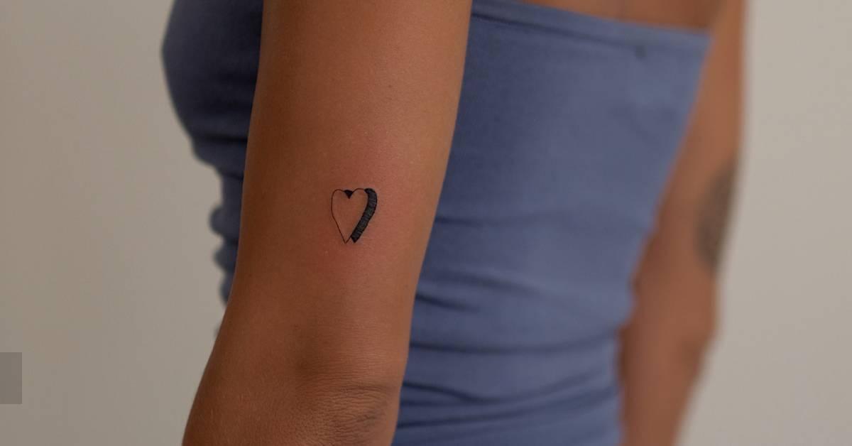 Minimalistic style heart tattoo located on the upper