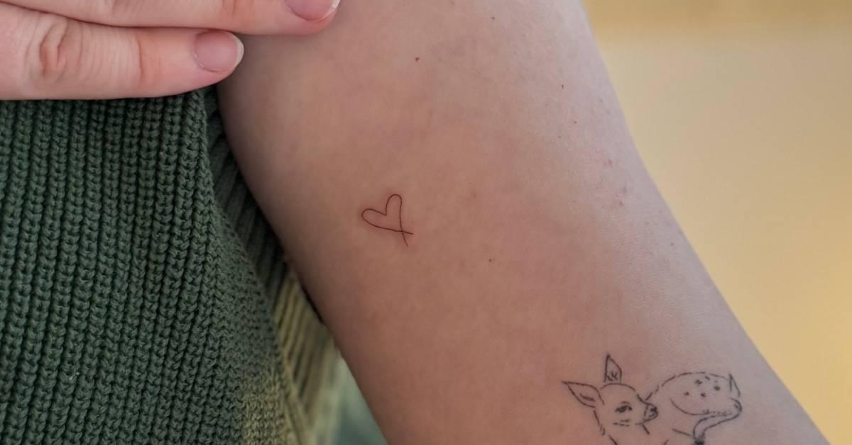 Tiny minimalistic heart tattoo placed on the inner arm.