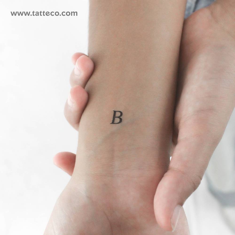 "B" serif capital letter temporary tattoo located on the wrist.