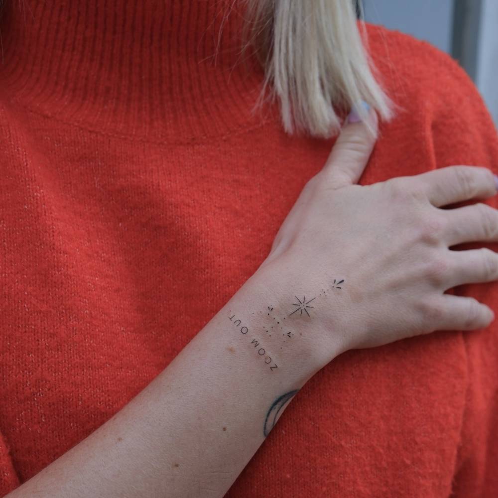 Fine line style ornamental tattoo located on the wrist.