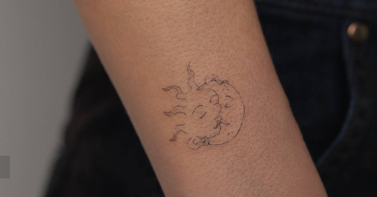 Fine line style kissing sun and moon tattoo located on