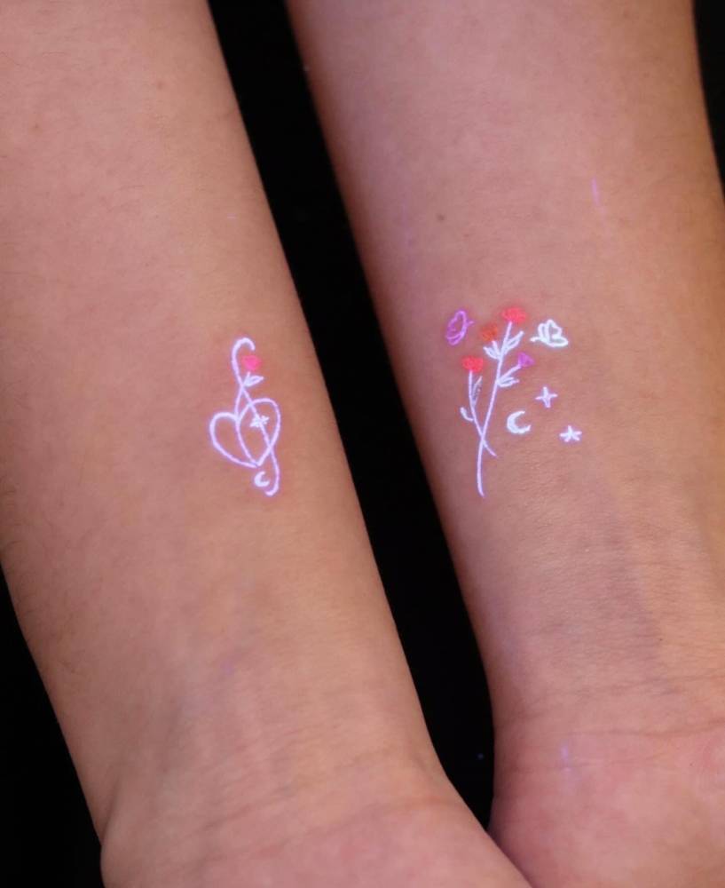 UV ink treble clef and flower bouquet tattoos in minimalistic style.