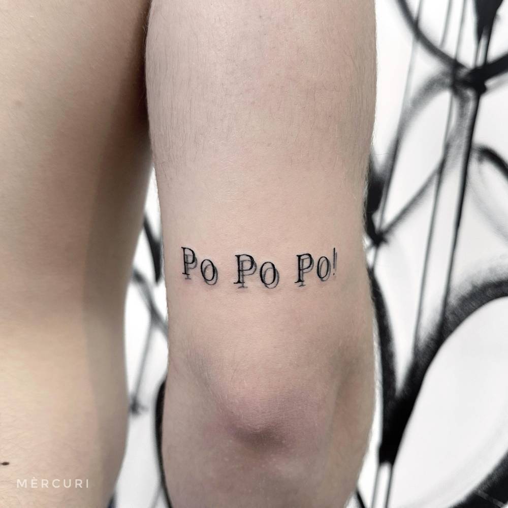 "Po Po Po" lettering tattoo in serif font located on the tricep.