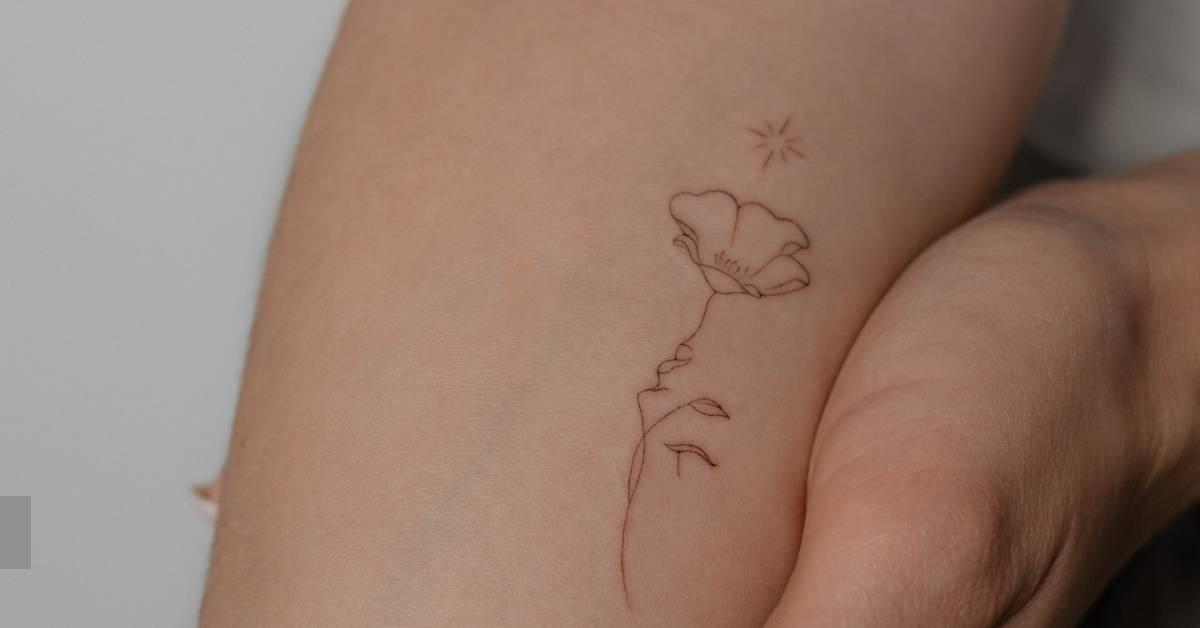 Flower head woman tattoo in fine line style located on