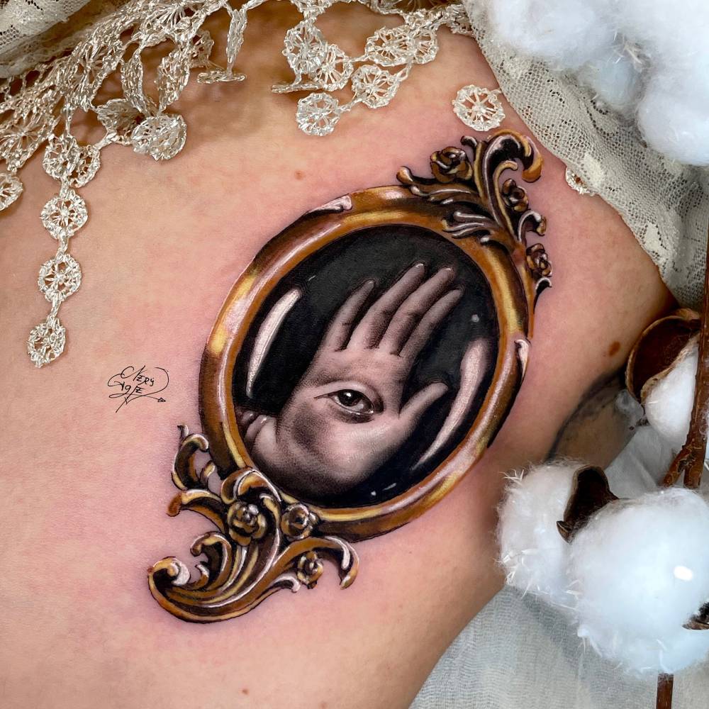 Realistic style frame and hand tattoo located on the rib.