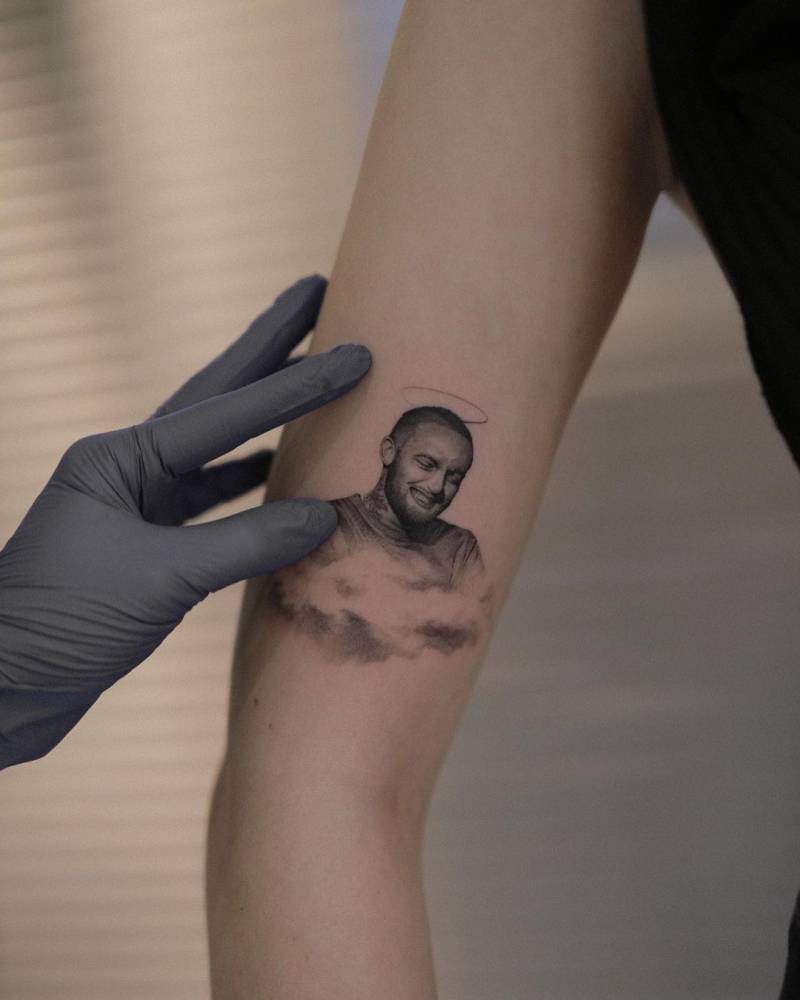 Micro-realistic Mac Miller portrait tattoo located on the upper arm.