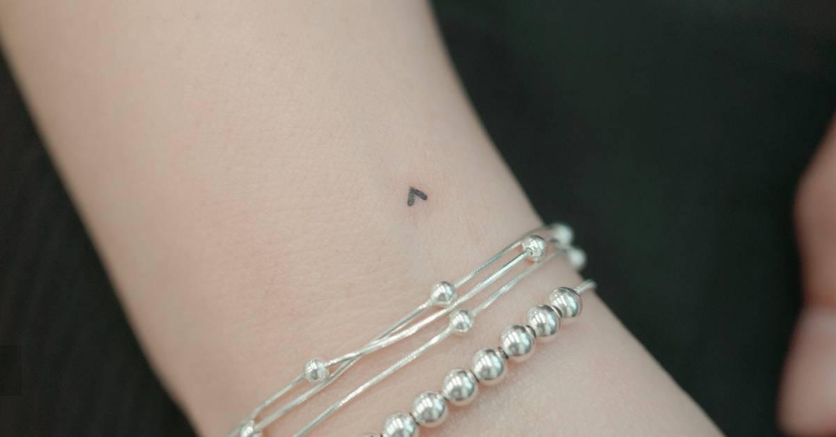 Tiny minimalistic heart tattoo located on the wrist.