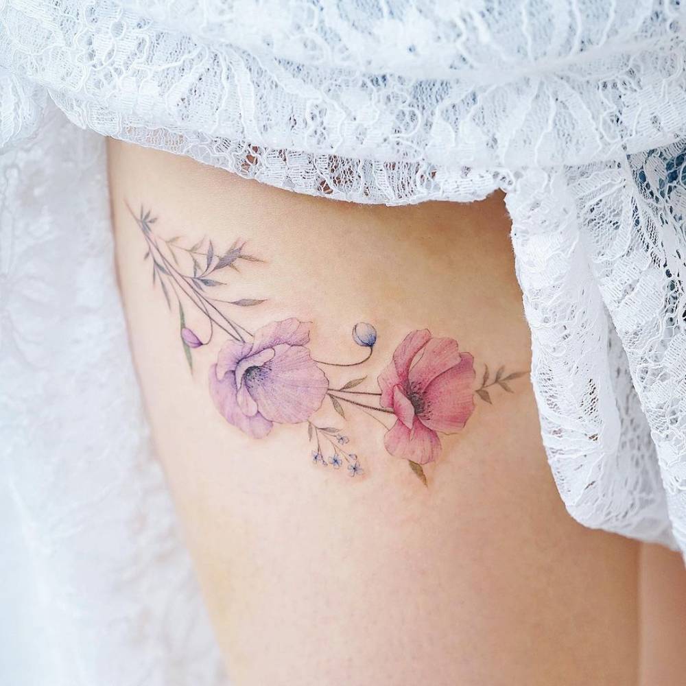 Watercolor style poppy flowers tattoo done on the thigh.