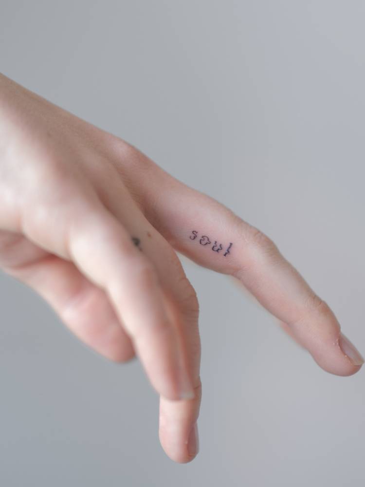 Blurry effect word "soul" tattooed on the finger.