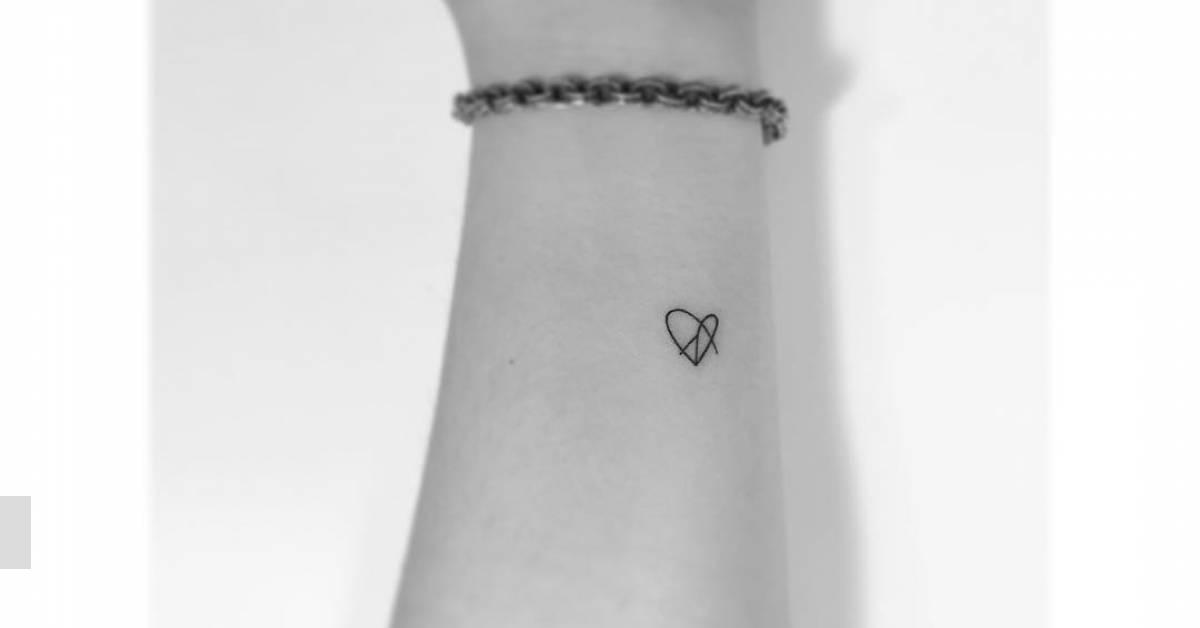 Peace heart tattoo in minimalistic style located on the