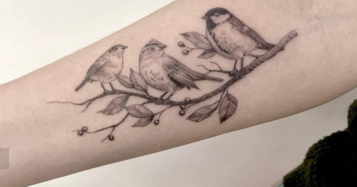 Black and grey style birds on a branch tattoo located