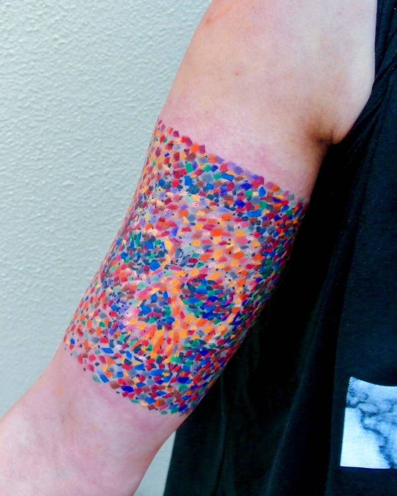 Watercolor style skull tattoo located on the inner arm.