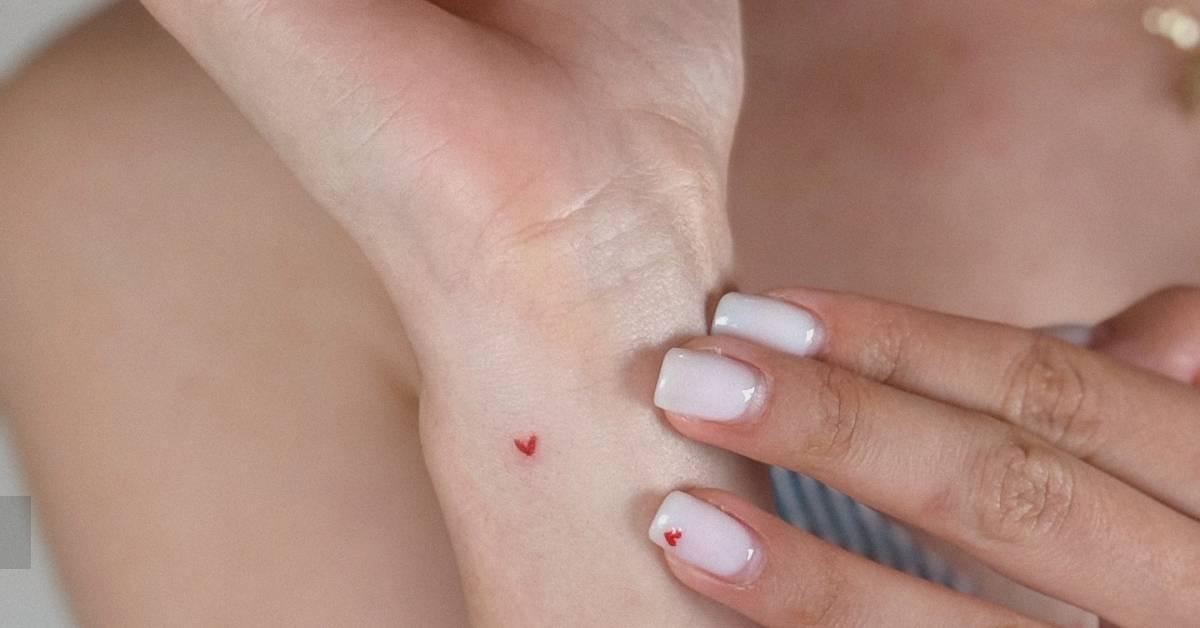 Tiny minimalistic red heart tattoo done on the wrist.