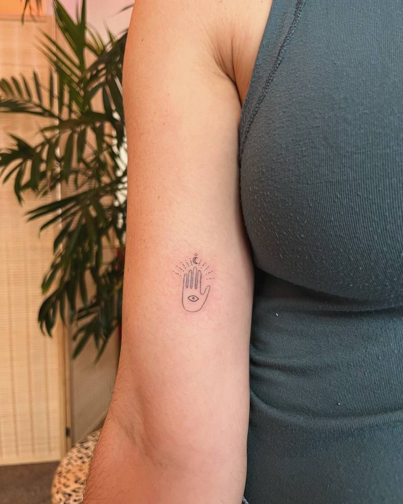 Hand poked minimalistic hand and eye tattoo located on the inner arm.