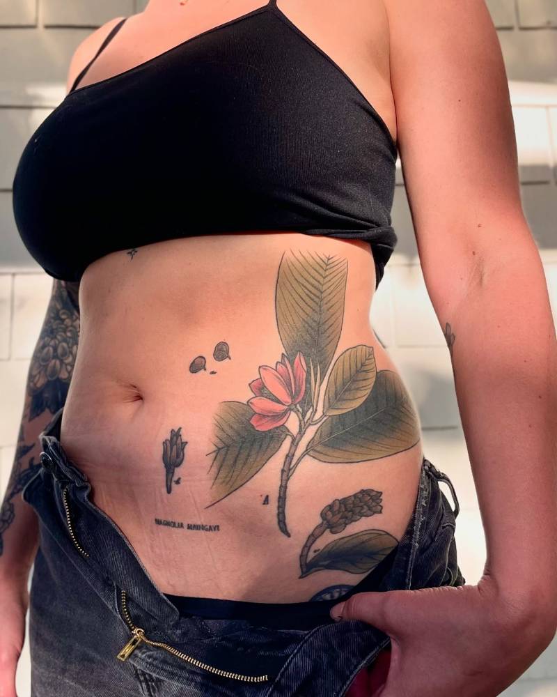 Illustrative style flower tattoo located on the waist.
