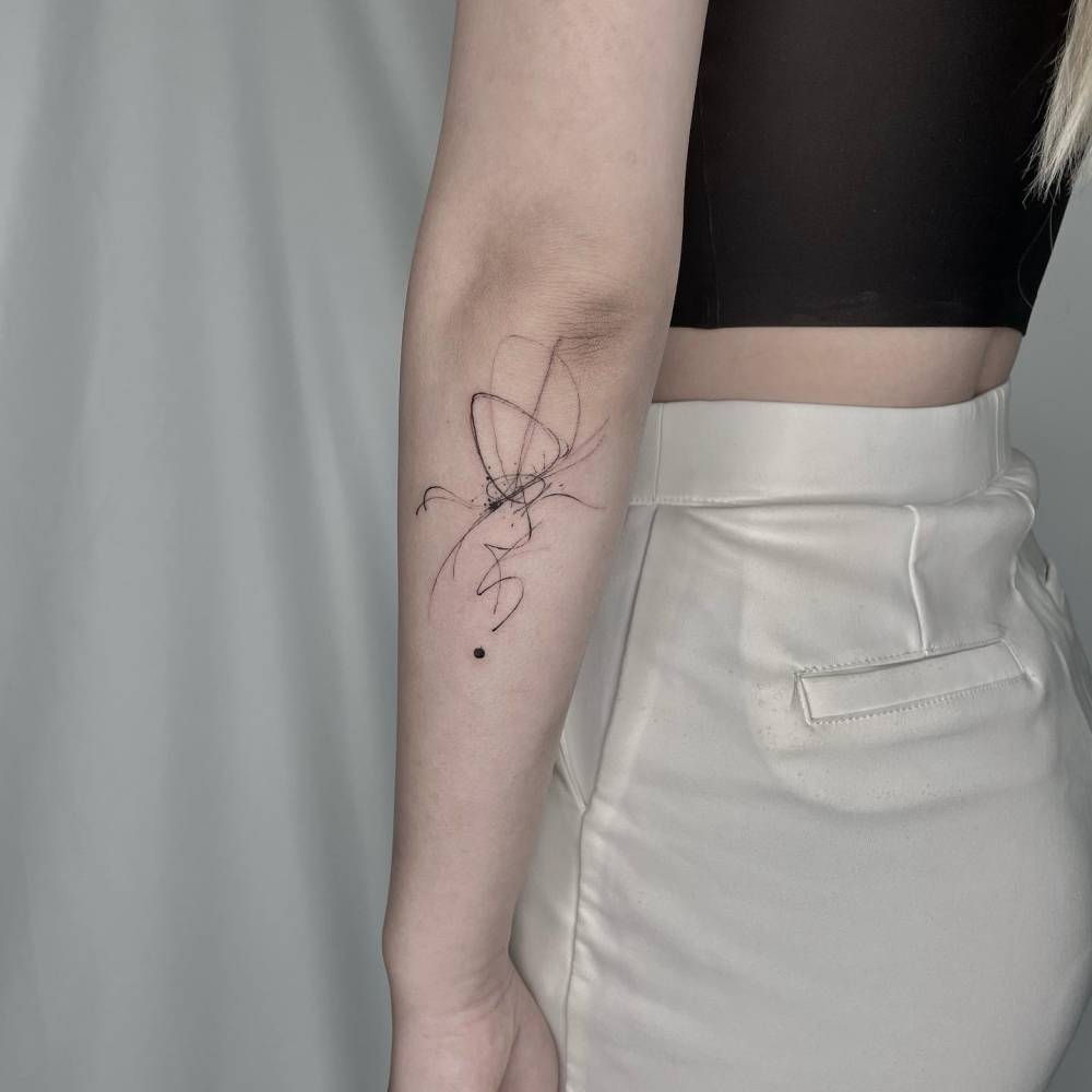 Abstract style butterfly tattoo located on the forearm.