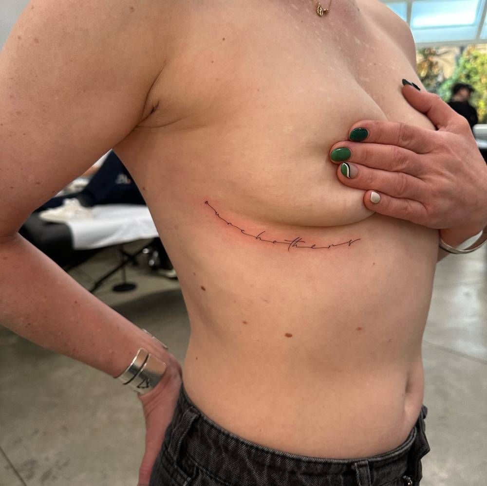 Handwritten lettering tattoo located on the under boob.