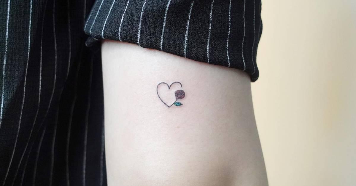 Minimalistic style heart and flower tattoo located on