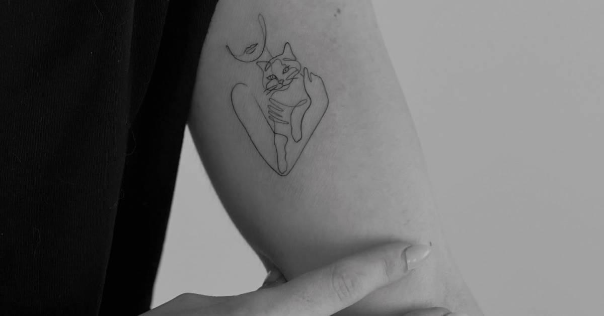 Continuous line woman and cat tattoo located on the