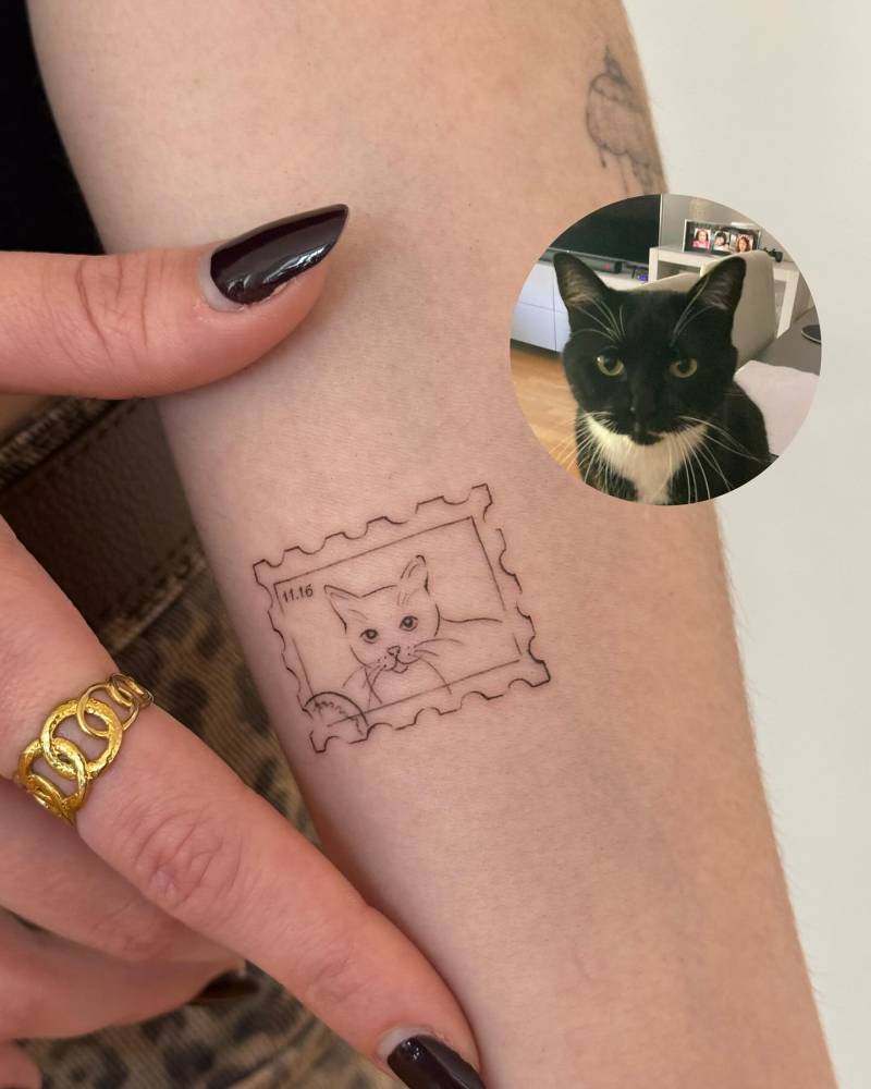 Cat portrait stamp tattoo located on the inner forearm.
