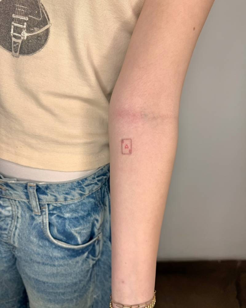 Fine line style little Ace of Hearts tattoo located on the inner forearm.