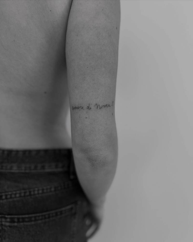 "Amore di nonna" lettering tattoo handwritten on the tricep.