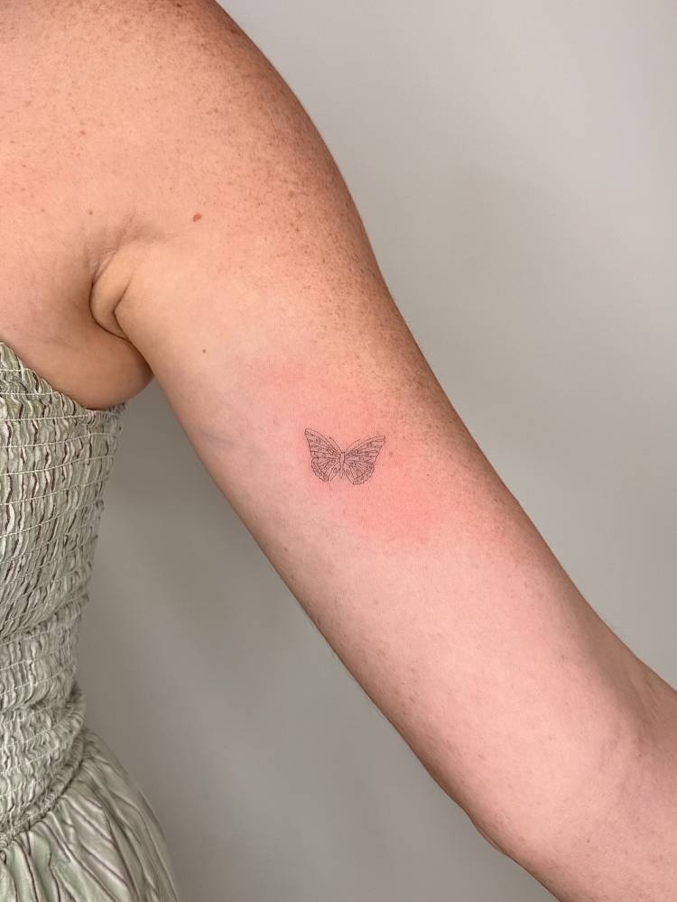 Single needle butterfly tattoo located on the inner arm.