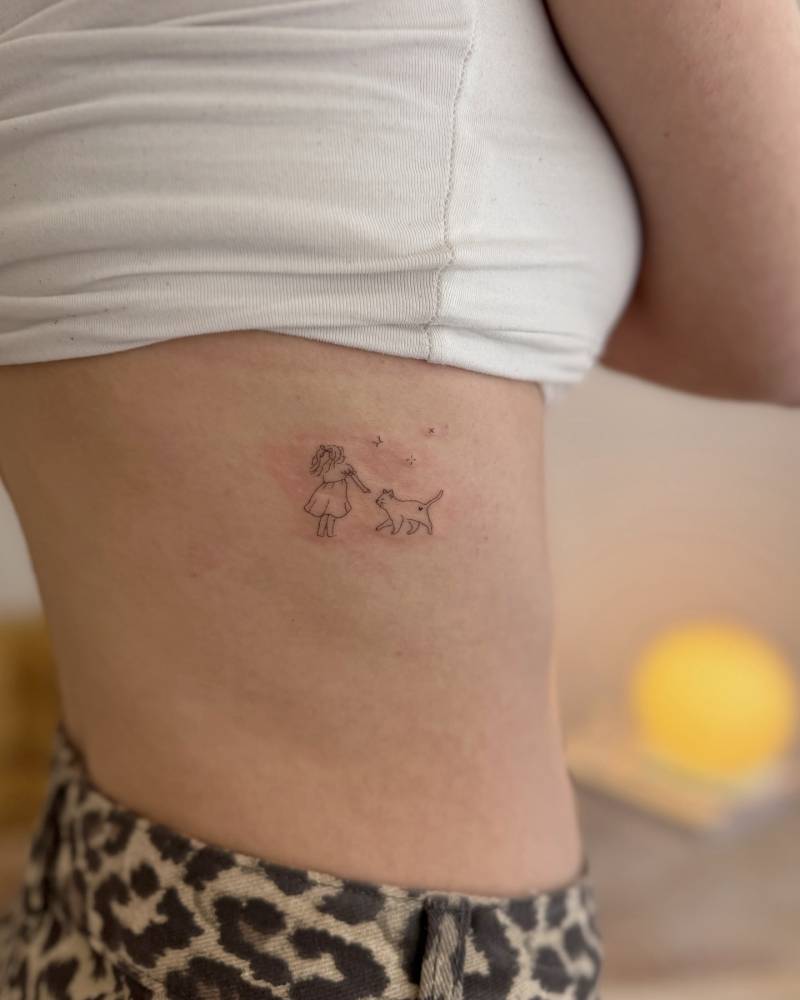 Girl and dog tattoo located on the rib, done in fine line style.