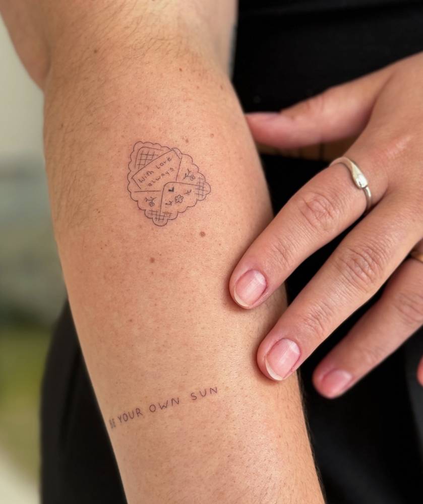 Little love letter tattoo located on the forearm, done in fine line style.