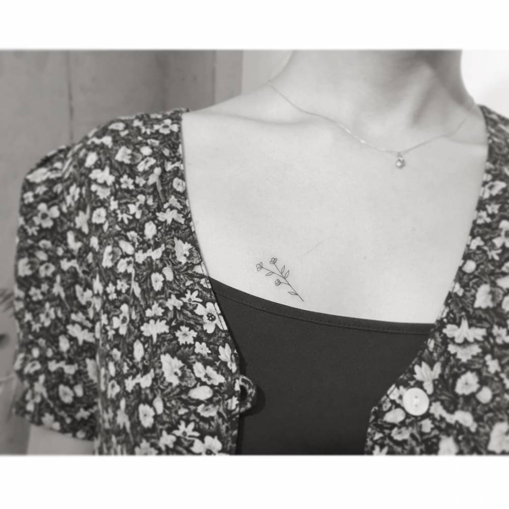 Minimalistic style flowers tattoo located on the chest.