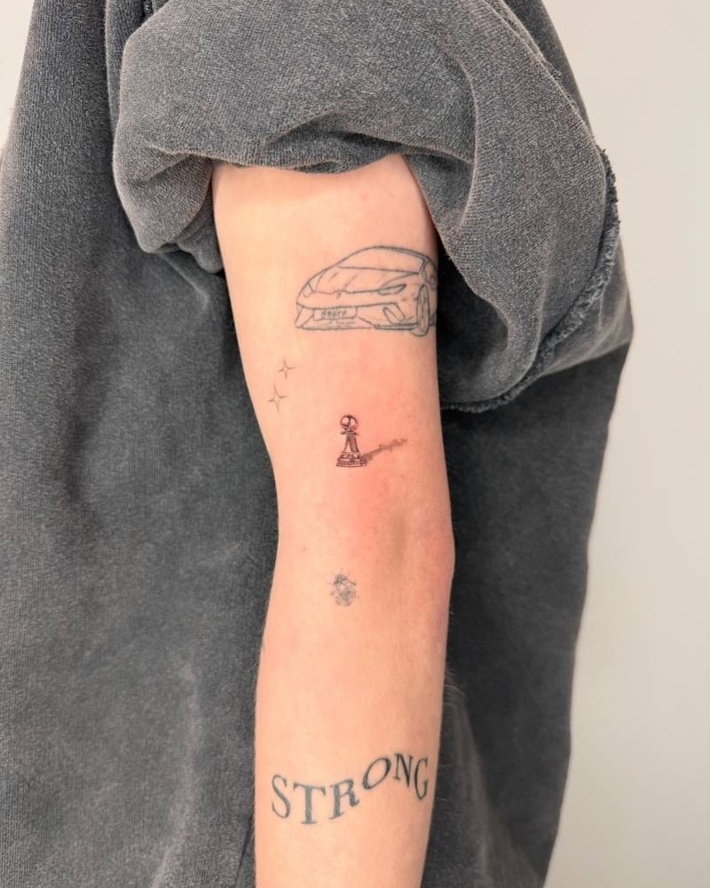 Single needle chess pawn tattoo located on the upper arm.
