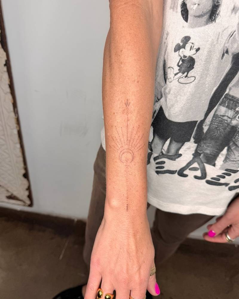 Fine line style ornamental moon tattoo placed on the forearm.