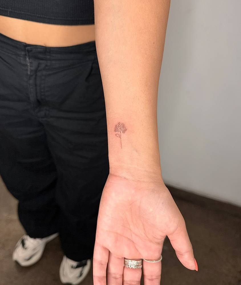Hydrangea flower tattoo in fine line style placed on the wrist.