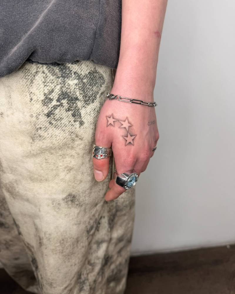 Dotwork style stars tattoo located on the hand.