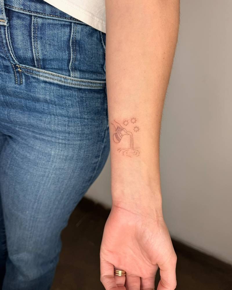 Jug pouring water tattooed on the wrist, done in fine line style.