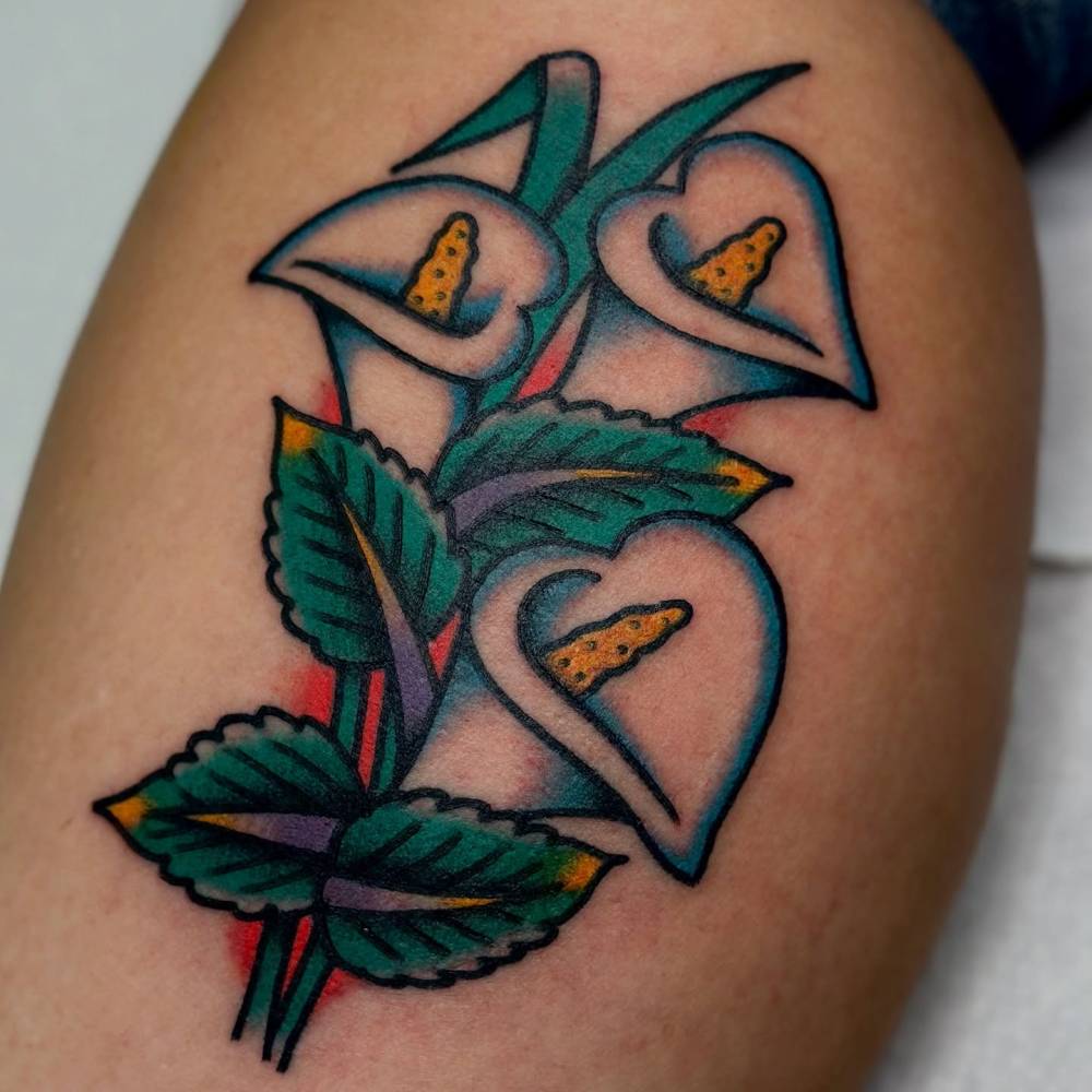 Traditional style calla lily flowers tattoo located on the calf.