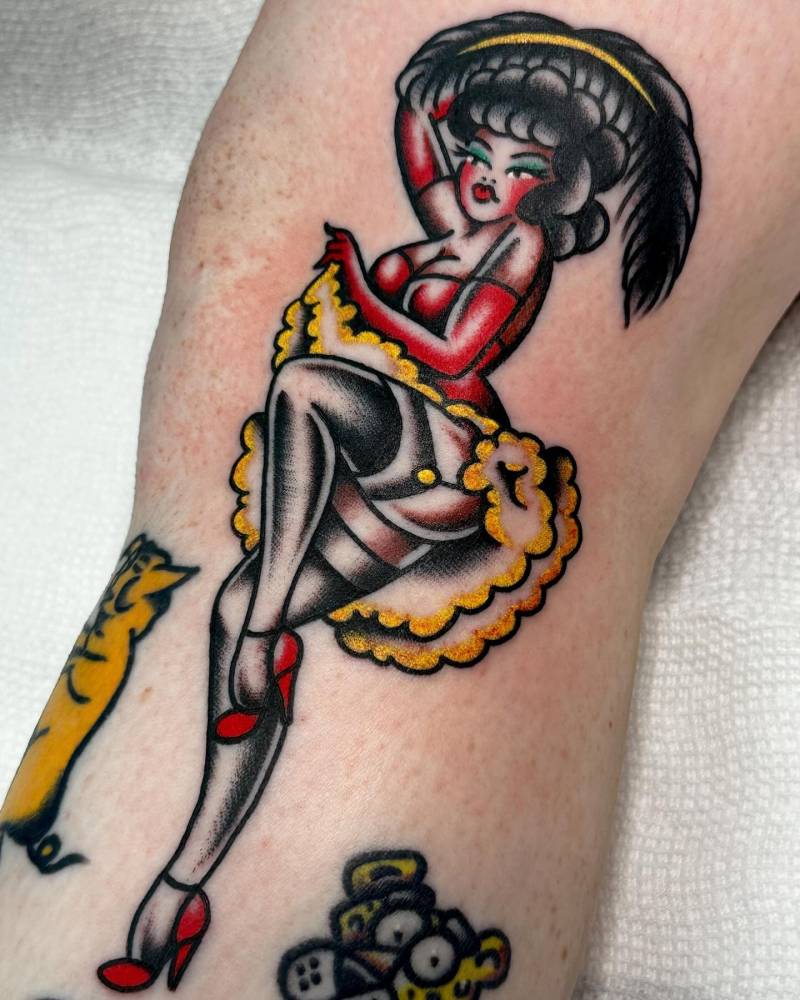 Pin-up tattoo in traditional style located on the knee.