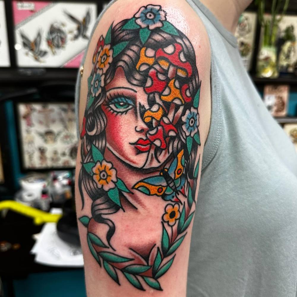 Traditional style woman portrait tattoo located on the upper arm.