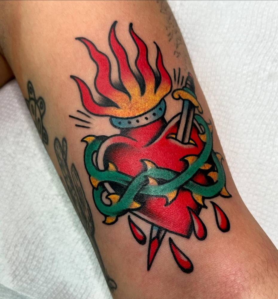 Traditional style Sacred Heart of Jesus tattoo located on the bicep.