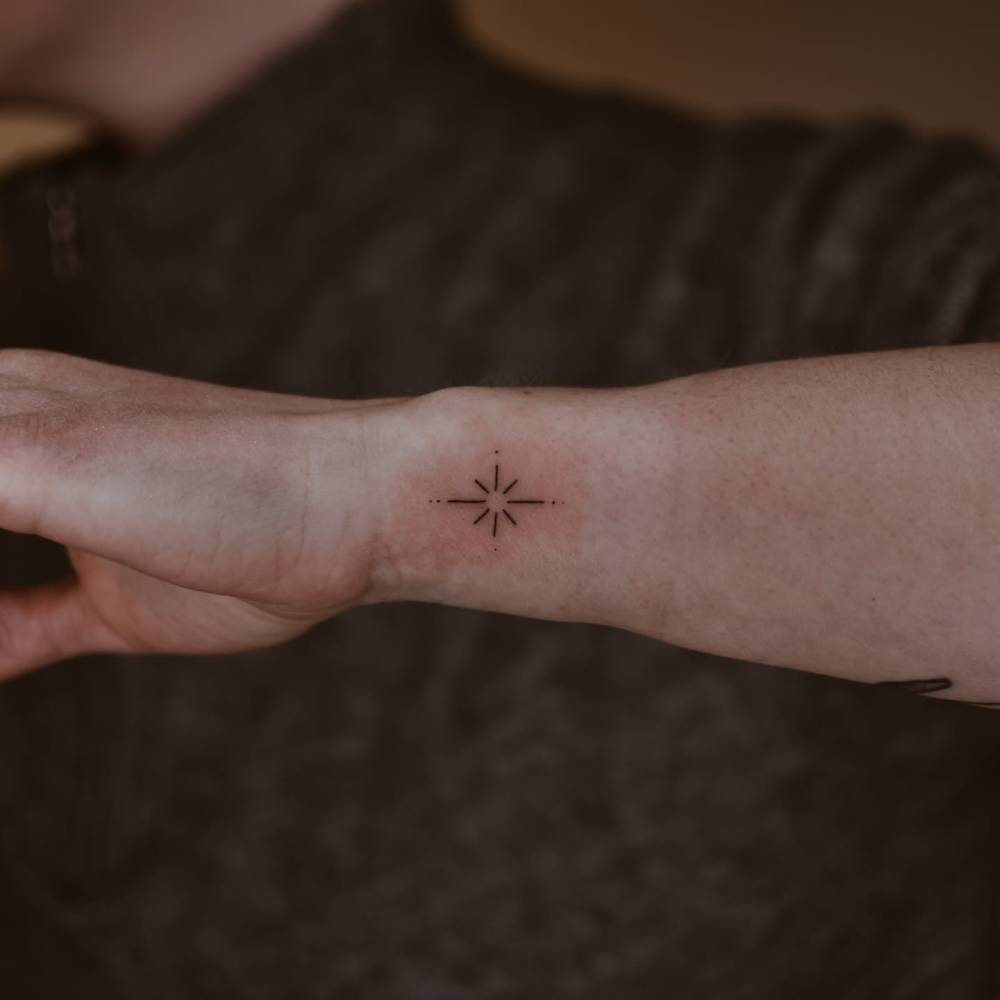 North star tattoo in minimalistic style placed on the wrist.