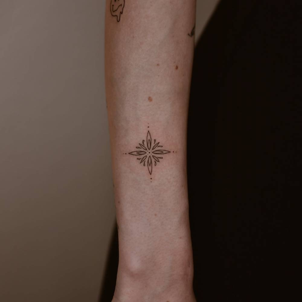 Fine line style ornamental tattoo located on the forearm.