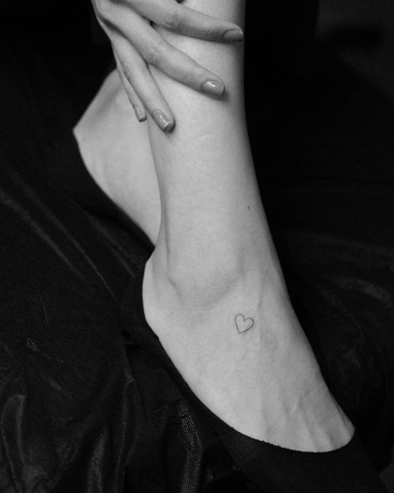 Heart tattoo in minimalistic style located on the foot.