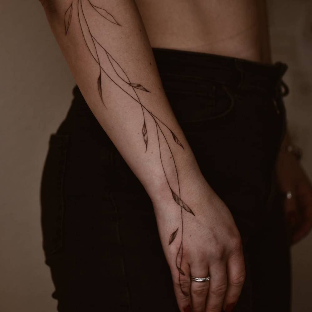 Leaves tattoo in illustrative style located on the forearm.