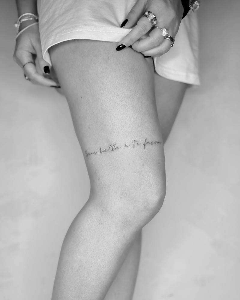 "Sois belle à ta façon" kettering tattoo located on the thigh.