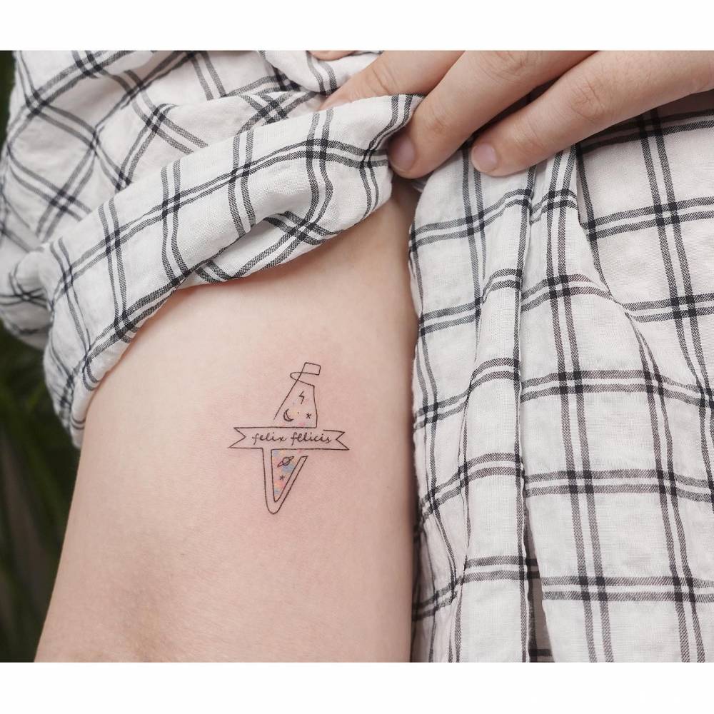 "Felix Felicis" tattoo located on the bicep, minimalistic style.