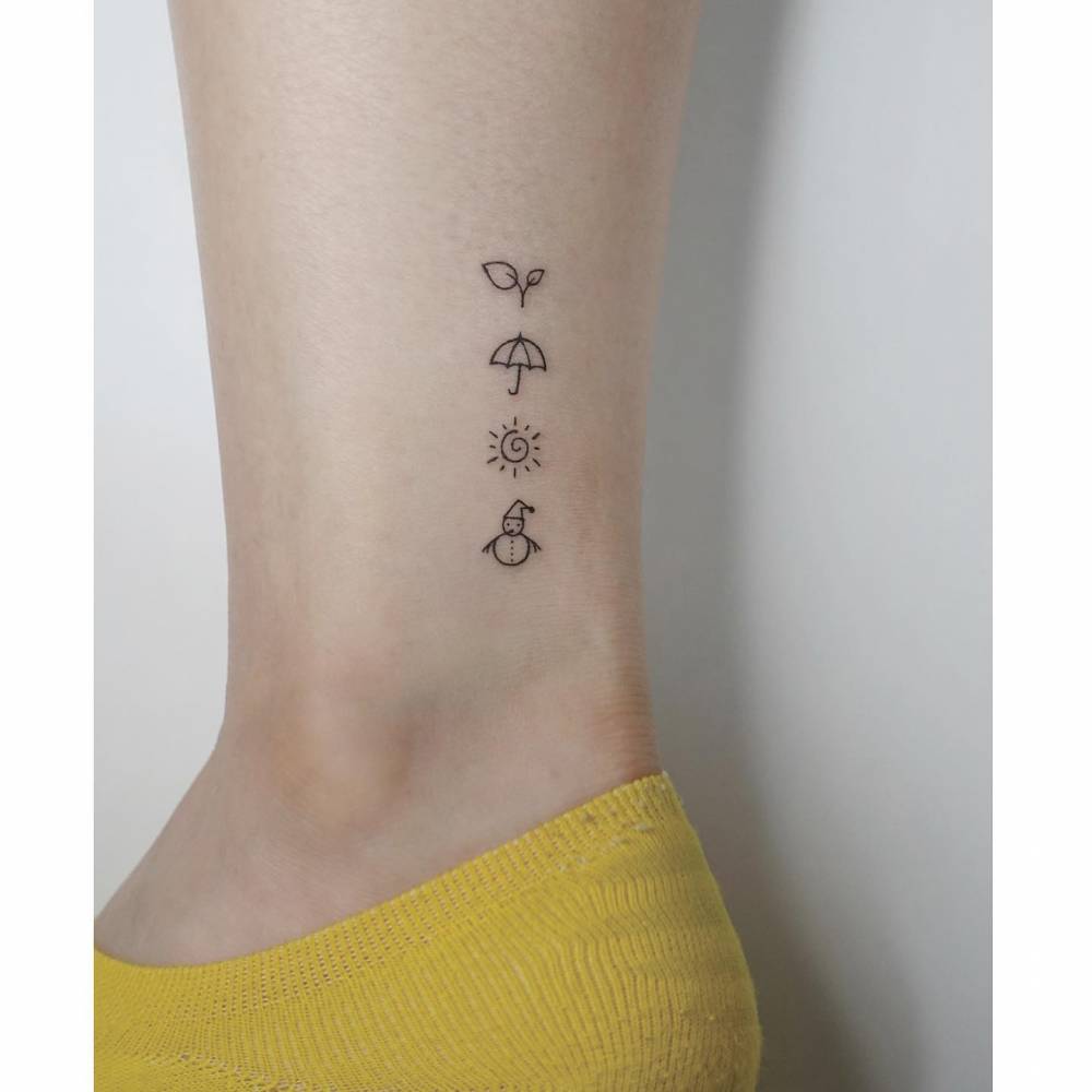 MInimalistic style sprout, umbrella, sun and snowman tattooed on the ankle.