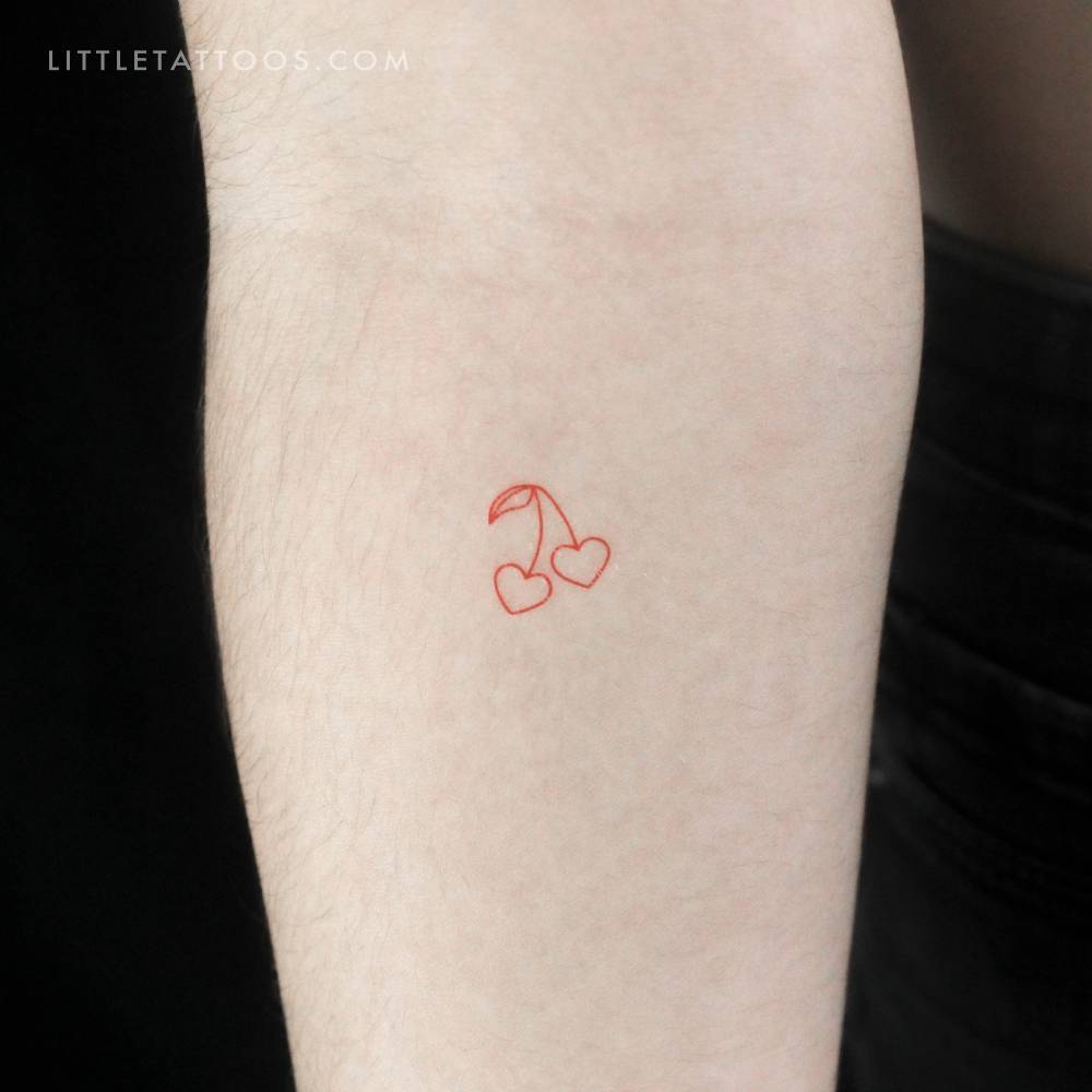 Small minimalistic red cherry couple temporary tattoo located on the inner forearm.