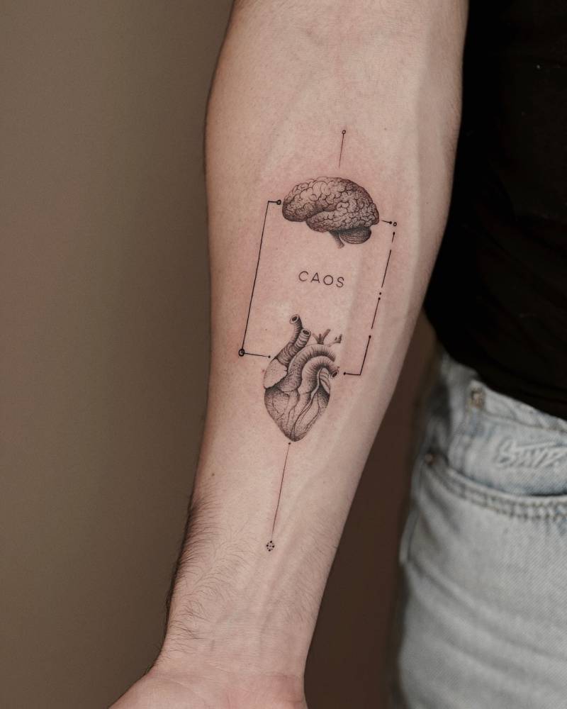 Heart vs brain tattoo in graphic style located on the inner forearm.